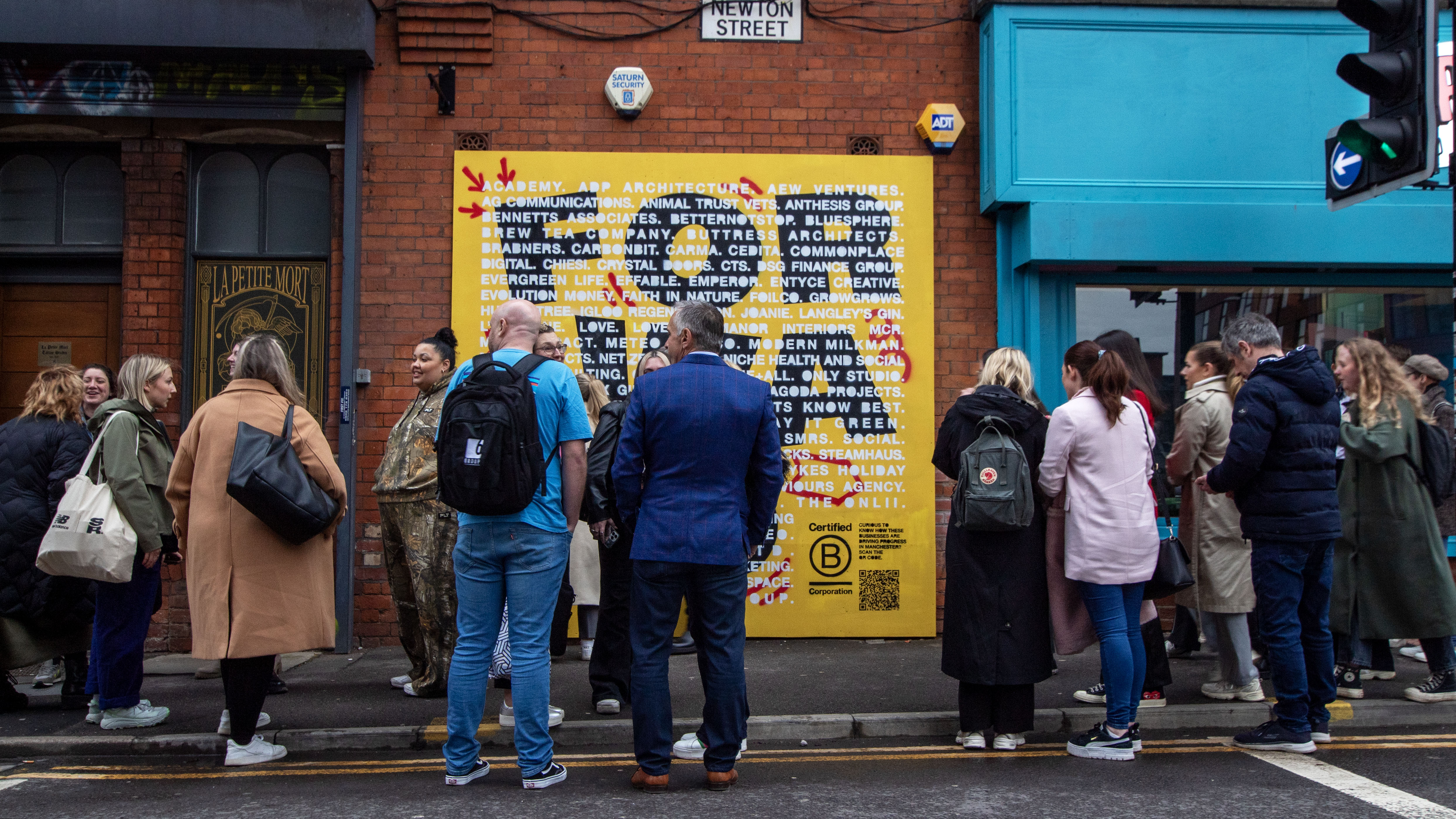 B Corp Month mural showing crowd around yellow mural