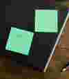 sticky notes and a pen on wooden table.