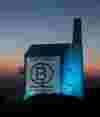B Corp certification logo projected on a tall stone building with blue light.