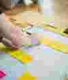 A person writing on yellow sticky memos on a large paper.